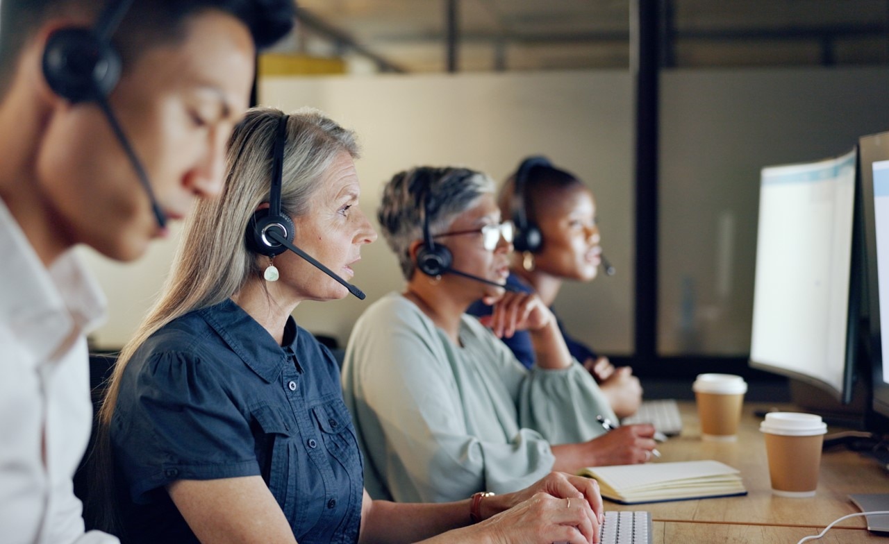 Four colleagues working side-by-side in a call center
