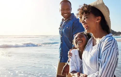 Two adults and a child walking on the beach