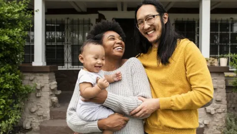 family standing in front of their house